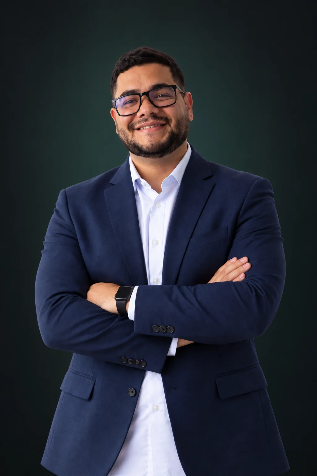 Retrato de Mayezer S. de Souza, de óculos e blazer azul, com os braços cruzados.